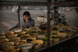 fotojournalismus:  A food vendor waits for customers at a market on November 21, 2014 in Hebei just outside Beijing, China. (Kevin Frayer/Getty Images)