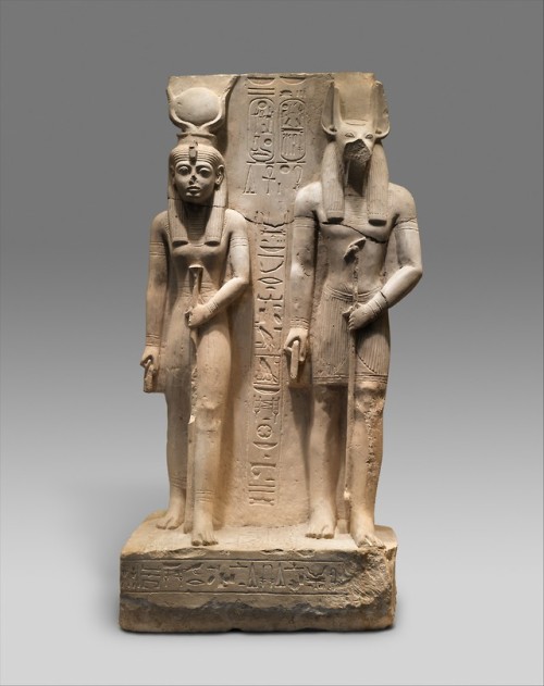 Ancient Egyptian limestone statue depicting the goddess Isis and Wepwawet, wolf-headed deity from th