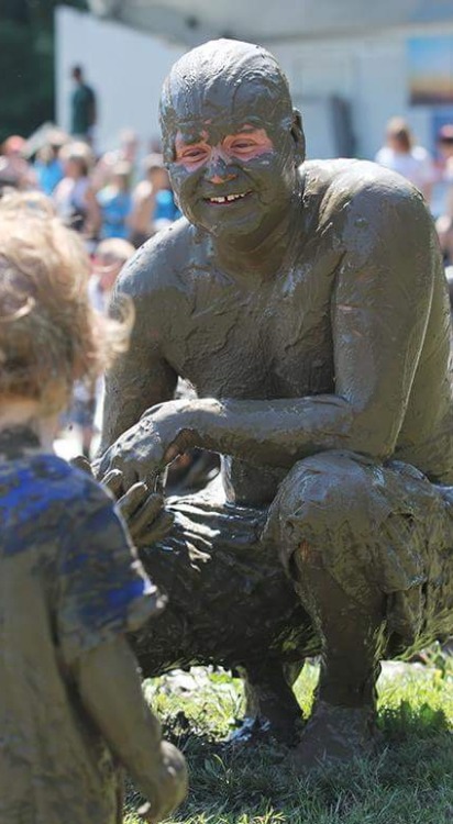 Father getting muddy with his little boy