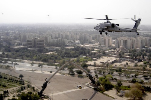 militaryarmament:  A U.S Army AH-64 Apache flying over the Victory Arch, Baghdad, Iraq. 2005.