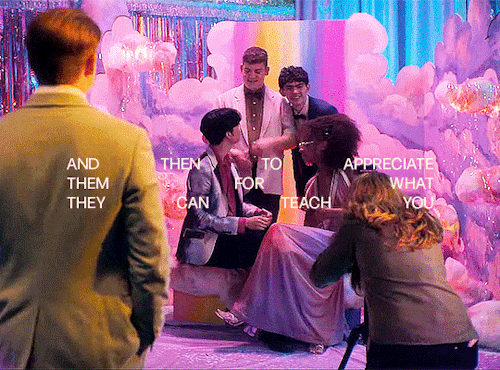 Isaac, Charlie, Tao and Elle are taking a group photo at prom. They're leaning onto each other. Nick is watching them from a distance. The text in the gif says: "and then to appreciate them for what they can teach you"