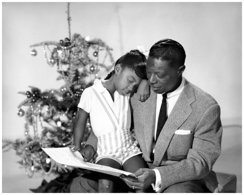 Nat King Cole with his daughter Natalie Cole at Christmas time (1955)