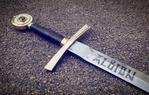 Commission work, based on the popular TV series of the 80s, though with a few changes in the runic script, and the replacement of the lion head in the pommel by a wolf’s head.
Etched spring steel blade, brass fittings with a hand-scuplted/cast wolf...