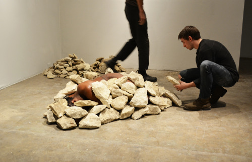 janemba:theletteryogh:colorthefuture:Ruins (2015), Carlos MartielI lay in the fetal position naked on the floor of the gallery, two Caucasian men covered me with rocks until my body became invisible.  is this art?If so, I don’t get it  Well you’re