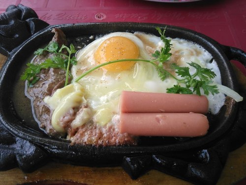 Sizzling plate of bò né.