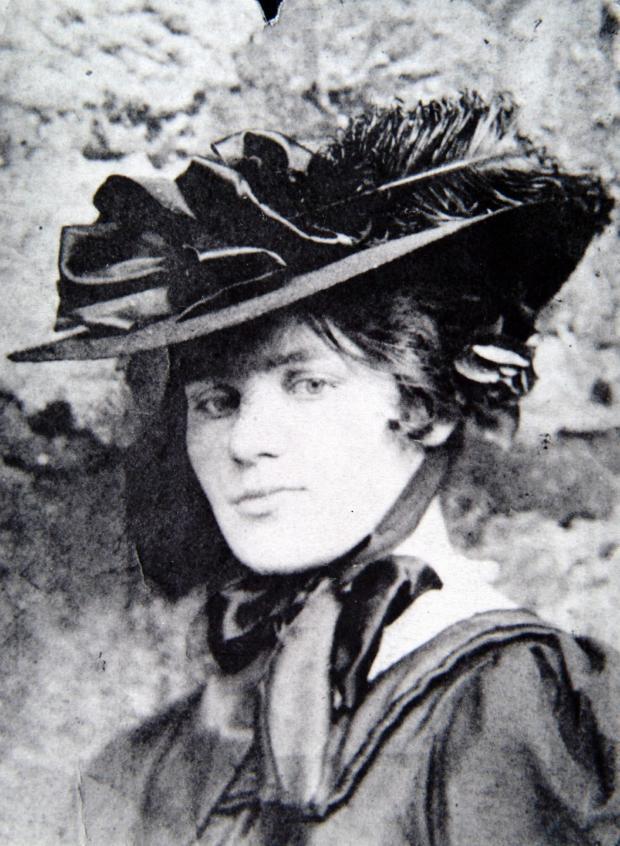 Black and white photo of Jessie M King. She is looking confidently at the camera in an impressively massive hat