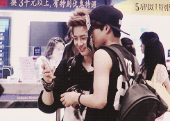 jongins:  suho messing around with kai’s bandana and taking photos of him 