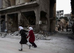 biladal-sham:  Two Syrian girls on a heavily damaged street in the rebel-held town of Douma, on the eastern outskirts of the capital Damascus. Sameer Al-Doumy/AFP