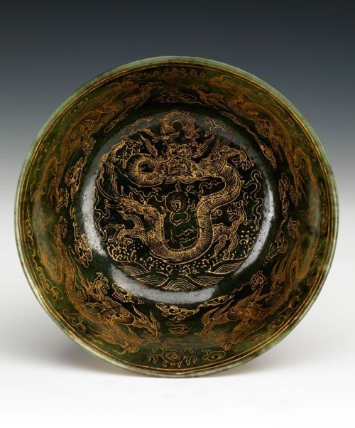 Jade bowl Diameter: 17 cm. China, 18th centuryCut and gilded spinach-green jade. On a wide footrim w