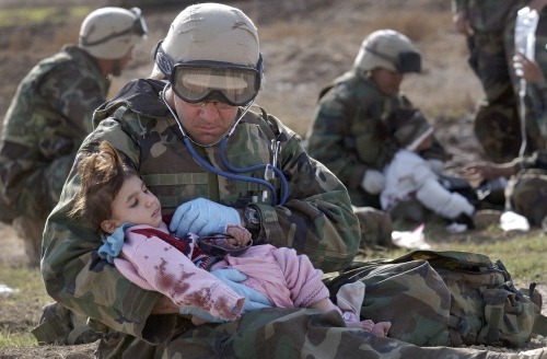 Navy Corpsman Richard Barnett of Camarilo, Calif. checks the heart of a young Iraqi