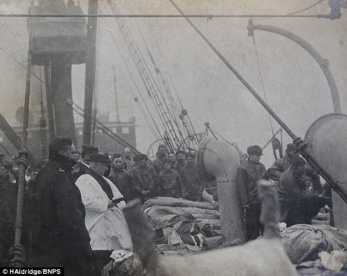 A priest praying over the victims of the Titanic (1912).