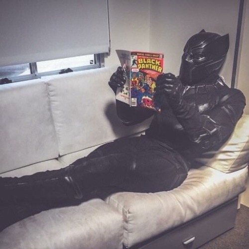 chadwickboseman-lovers: A pic of Chadwick Boseman, in Black Panther gear, reading Black Panther comi