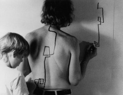 likeafieldmouse:  Dennis Oppenheim - Two-stage Transfer Drawing (1971) &ldquo;As I run a marker along Eric’s back he attempts to duplicate the movement on the wall. My activity stimulates a kinetic response from his sensory system. I am, therefore,