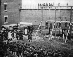 A crowd in the yard of Washington DC&rsquo;s Old Penitentiary, watching the hanging of Mrs Surratt and John Wilkes Booth&rsquo;s conspirators in the plot to kill President Lincoln. The conspirators were Mrs. Surratt, Lewis Payne, David Herold, and George
