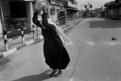 tamarrud:  An elderly woman attempts to break a large rock into smaller stones for Palestinian youth to throw against advancing Israeli tanks in Gaza City in 1993. Photo credit: Larry Towell 