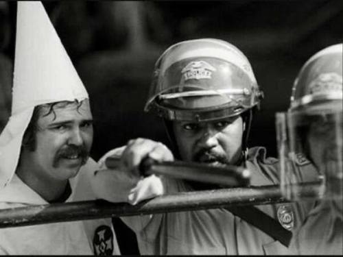 historicpicturess: Texas, 1983. Incoherence of human kind in one picture. A Ku Klux Klan member is h