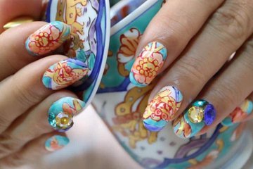 Intricate nail art mimicing the shishi (Japanese heavenly lion) design of a Manemon teacup (porcelai