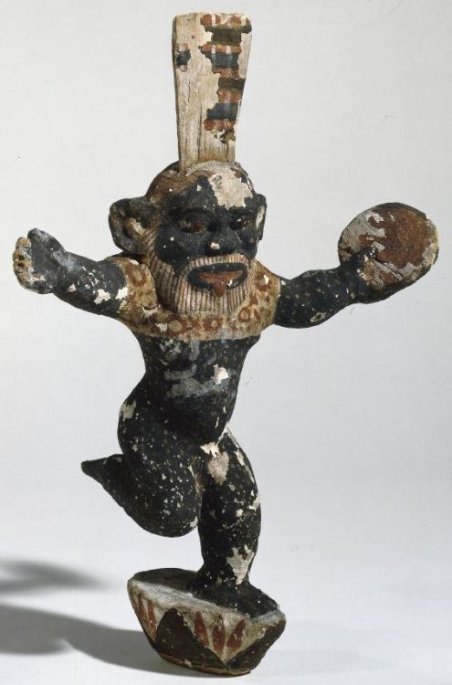 Wooden figure of Bes standing on a lotus, holding a tambourine and dancing