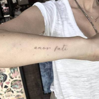 Amor fati tattoo on Lisas left wrist
