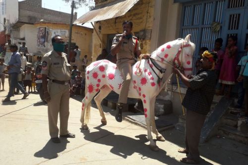 A police officer riding a horse covered with coronavirus-themed paintings conducts a coronavirus awa