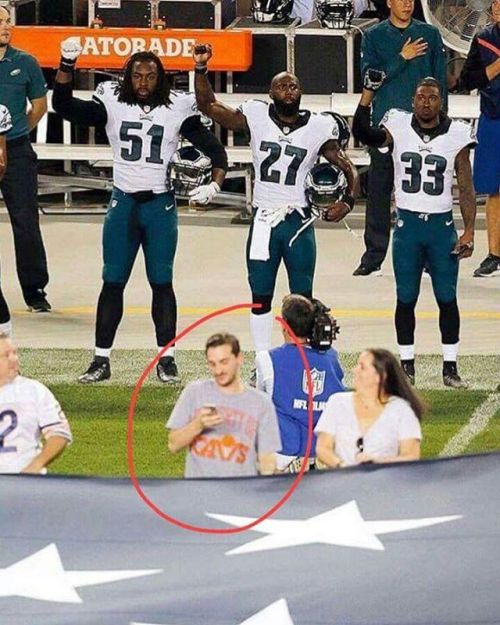Raising a fist to raise awareness is disrespectful. Playing on your phone while holding the flag isn