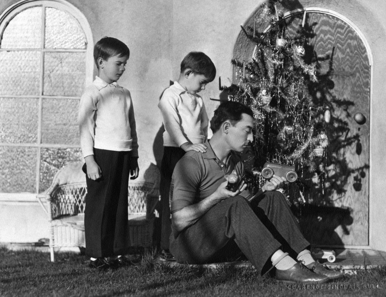 The Academy — Buster Keaton, seated next to a Christmas tree in...