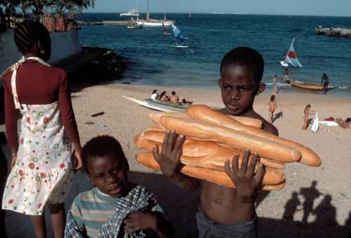 sickpage:Bruno BarbeySENEGAL. Island of Goree, near Dakar. A boy carries French baguettes. 1980.