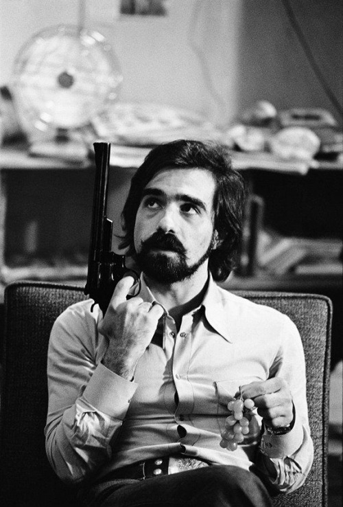 weirdvintage:  Martin Scorsese holding a gun and grapes during the filming of Taxi Driver (1976), photo by Steve Schapiro, via Lomography 