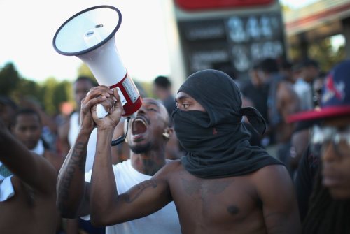  Demonstrators protest the killing of teenager Michael Brown in Ferguson, Mo. on August 12, 2014. 