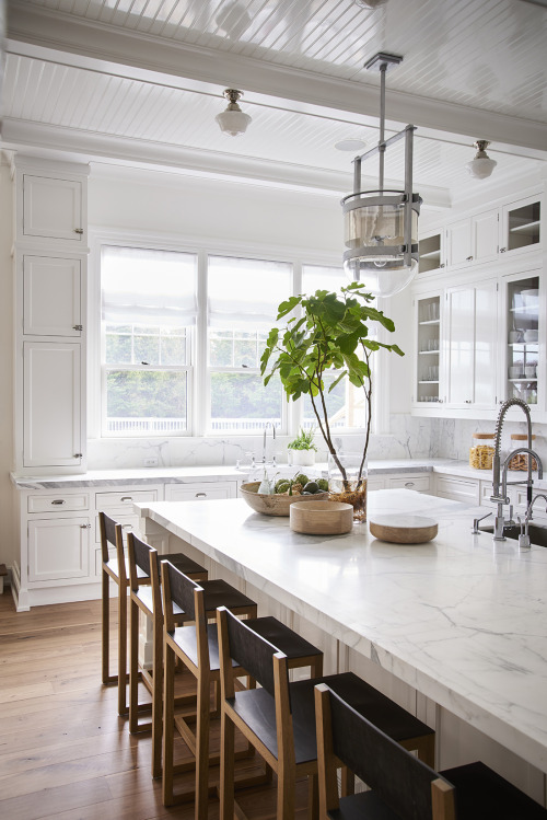 Bright kitchen features a marble island and matching backsplash in this home located in Bridgehampto