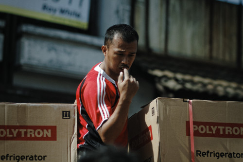 Porn Man unloads boxes of polytron refrigerator. photos