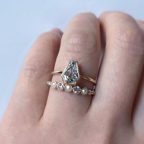 This sparkly shield cut diamond set in an understated bezel setting paired here with our Leila Ring 
