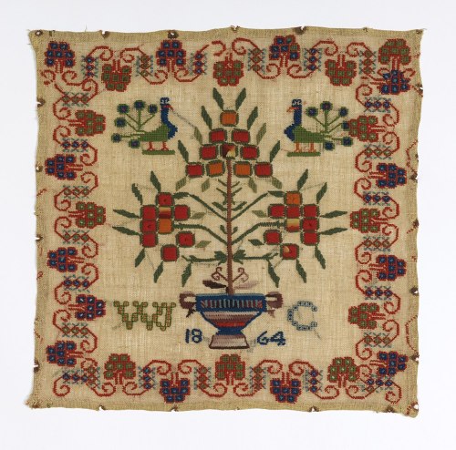 Sampler (English, 1864).  Flowering plant in a vase; two peacocks within a border.Wool embroidery on