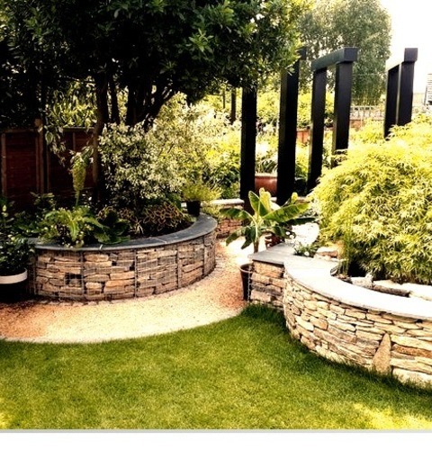 Modern Landscape - LandscapeInspiration For A Mid-sized Modern Full Sun Backyard Stone Retaining Wall