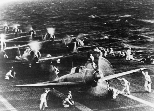 Japanese pilots heading for their aircraft, and dive-bombers spinningup on the deck of a carrier bef
