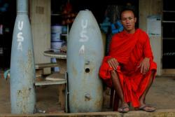 troposphera:  A Buddhist monk poses next to unexploded bombs dropped by the U.S. Air  Force planes during the Vietnam War, in Xieng Khouang in Laos September  3, 2016. REUTERS/Jorge Silva