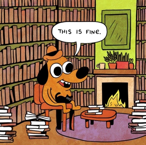 the 'this is fine' meme, but dog is sitting in a room full of books, with a cat on his lap. the mug is too far away, on the mantle of the fireplace