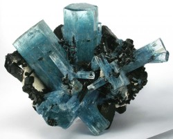 fuckyeahmineralogy:  Aquamarine, a color of beryl (Be3Al2(SiO3)6) with schorl; aquamarine gains its blue color from Fe2+ ions.  Schorl is the most common type of tourmaline.