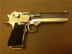 gunrunnerhell:  Chrome A Desert Eagle with the usual “bling”. It’s one of the few pistols where gold is a factory finish option. Note the very small port in the barrel near the muzzle. Before Magnum Research released their muzzle brake, the company