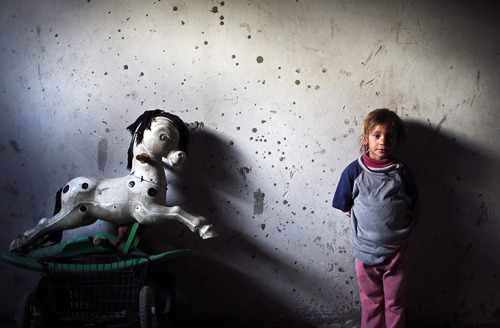 Four-year-old Jehan Soboh, a Palestinian refugee, stands beside her toy in her family home in Beit L