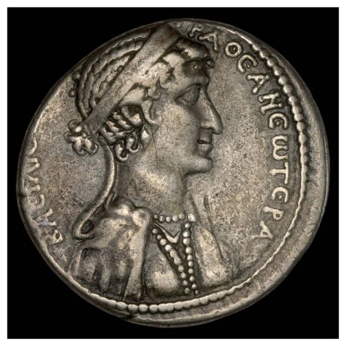 Coin with the image of Cleopatra facing right wearing diadem, earring, pearl necklace, and dress emb