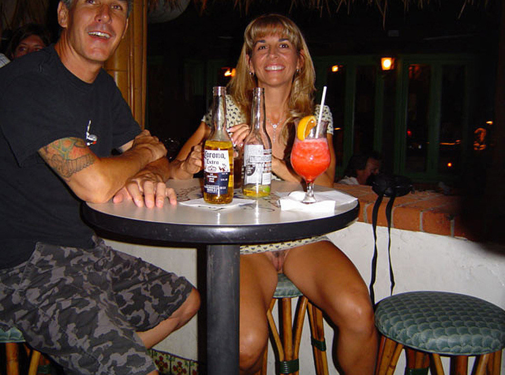 Pretty girl smilingly flashing her pussy in a bar. The guy is smiling too, her exhibitionist