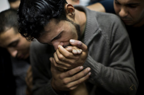 1:  Nov. 18, 2012 file photo, a Palestinian man kisses the hand of a dead relative in the morgue of 