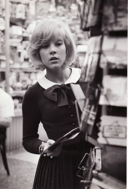 sylvie-vartan:  Sylvie browsing postcards in Paris, c. 1964 