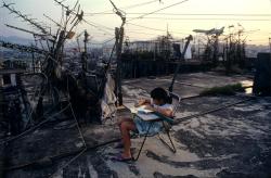 Unrar:  Student Doing Homework On Walled City Rooftop, 1989, Greg Girard. 