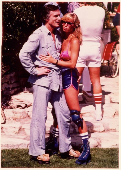 Captured roller skating and talking to friends, Hugh Hefner enjoys his 1979 Playboy Mansion Rollerpa