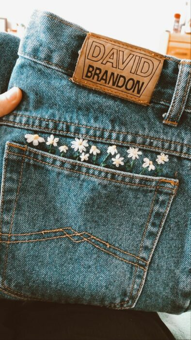 A pair of David Brandon jeans with embroidered daisies above the pocket.