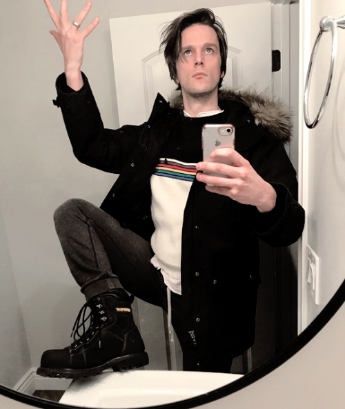 Dallon Weekes Wife&rsquo;s rainbow sweater. Dark grey sweatpants. Big &lsquo;ol Caterpillar 
