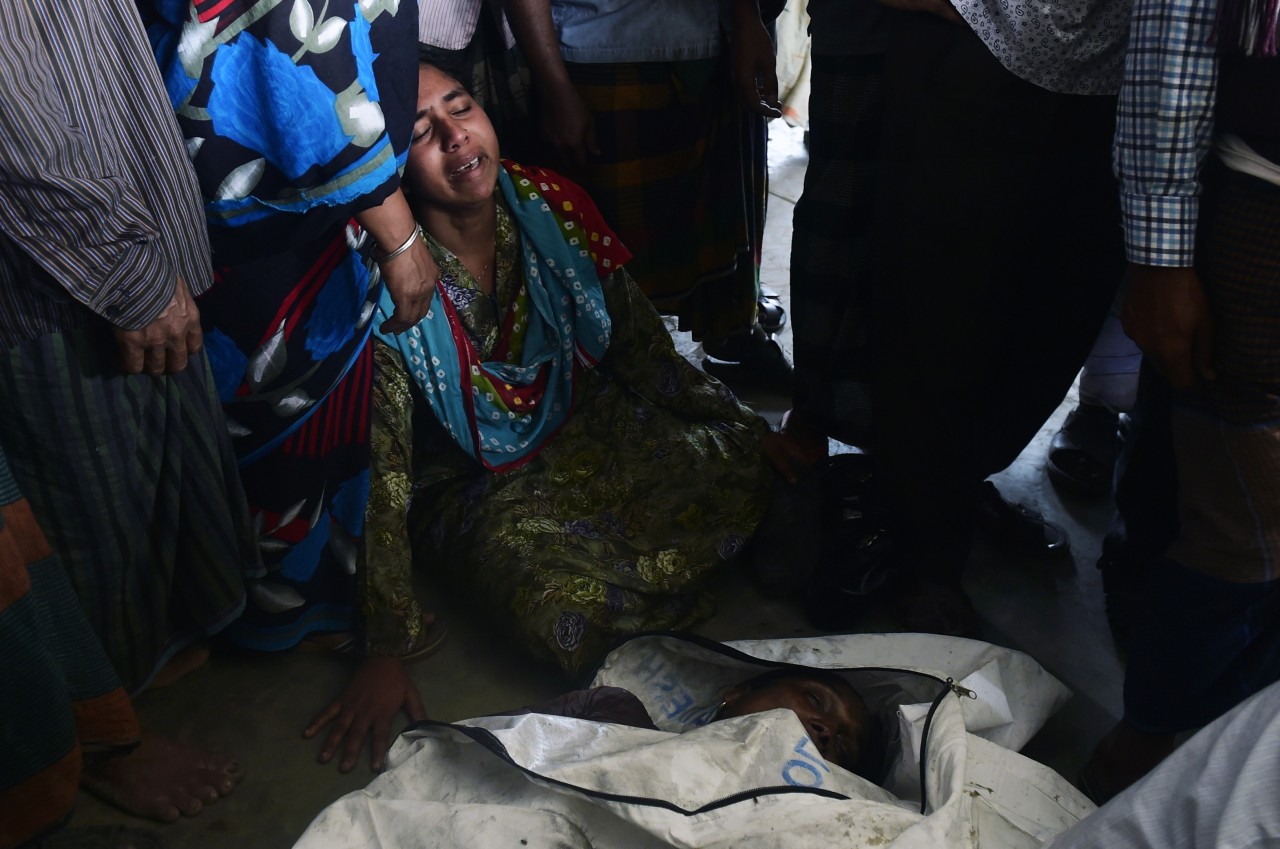 BANGLADESH. Una multitud observa el ferry naufragado en el Río Padma. Las autoridades informaron de 68 el número de muertos por el hundimiento ayer de un ferry con cerca de 200 pasajeros, tras colisionar con un carguero, en un río en el centro de...