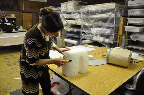 Associate Conservator Maria Fusco is carving archival ethafoam to make the base for a hip form. This